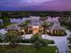 Luxury estate with beautiful landscaping, paver driveway and lake view at dusk at 18826 Ganton Ave, Lakewood Ranch, FL 34202