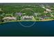 Aerial view showcases this exceptional home's location on a lake, surrounded by lush landscaping and mature trees at 18826 Ganton Ave, Lakewood Ranch, FL 34202