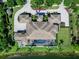 Aerial view of a large home with a beautiful backyard pool and lake access, surrounded by lush landscaping at 18826 Ganton Ave, Lakewood Ranch, FL 34202