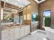 This large bathroom has a soaking tub, double sinks, and a mounted TV for relaxing nights at 18826 Ganton Ave, Lakewood Ranch, FL 34202