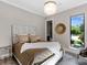 Bright bedroom with a plush bed, decorative lighting, and a large window overlooking a green landscape at 18826 Ganton Ave, Lakewood Ranch, FL 34202