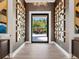 A modern foyer featuring mirrored wall decor, hardwood floors, and a view to the exterior through a glass door at 18826 Ganton Ave, Lakewood Ranch, FL 34202