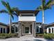 Striking modern home featuring a symmetrical facade, stone accents, a manicured lawn, and a covered entrance framed by palm trees at 18826 Ganton Ave, Lakewood Ranch, FL 34202