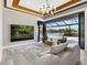 Bright living room with modern chandelier and water view through large sliding glass doors at 18826 Ganton Ave, Lakewood Ranch, FL 34202