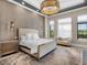 This gorgeous main bedroom has a beautiful bed, lots of natural light, and a calming color palette at 18826 Ganton Ave, Lakewood Ranch, FL 34202