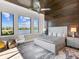 Serene main bedroom featuring a wood accent wall and expansive water views from multiple windows at 18826 Ganton Ave, Lakewood Ranch, FL 34202