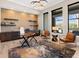 This cozy office has a stylish wooden desk, modern chairs, and gorgeous views through the large windows at 18826 Ganton Ave, Lakewood Ranch, FL 34202