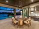 Elegant outdoor dining area with a large table, adjacent to a modern kitchen and scenic lake views at 18826 Ganton Ave, Lakewood Ranch, FL 34202