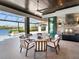 Inviting outdoor dining area with a full kitchen, BBQ, and views of the pool and lake at 18826 Ganton Ave, Lakewood Ranch, FL 34202