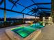 Stunning backyard pool and spa at dusk with colorful lights, enhancing the peaceful waterfront atmosphere at 18826 Ganton Ave, Lakewood Ranch, FL 34202