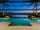 Gorgeous waterfront pool at twilight, complete with fire features and colorful lighting, creating a relaxing ambiance at 18826 Ganton Ave, Lakewood Ranch, FL 34202