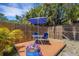 Backyard patio with a blue umbrella and seating set, surrounded by tropical landscaping at 2647 Britannia Rd, Sarasota, FL 34231