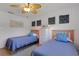 Bright bedroom featuring hardwood floors, ceiling fan, and matching twin beds at 2647 Britannia Rd, Sarasota, FL 34231