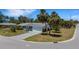 Charming single-story home boasts a well-manicured lawn, palm trees, and a paved driveway at 2647 Britannia Rd, Sarasota, FL 34231