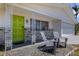 Charming front porch with seating, decorative columns, and a vibrant green front door at 2647 Britannia Rd, Sarasota, FL 34231