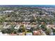 Expansive aerial view of a residential neighborhood with lush greenery and a glimpse of the ocean in the distance at 2908 Mayflower St, Sarasota, FL 34231