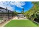 Charming backyard featuring a brick firepit, chairs, manicured lawn, and lush tropical landscaping under a bright, sunny sky at 2908 Mayflower St, Sarasota, FL 34231