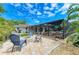 Well-manicured backyard features a brick firepit, comfortable seating, lush tropical foliage, and a screened-in pool area at 2908 Mayflower St, Sarasota, FL 34231