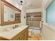 Bathroom with wooden vanity, marble countertop, and tiled shower and a decorative mirror on the wall at 2908 Mayflower St, Sarasota, FL 34231
