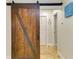 Hallway with a sliding barn door and neutral colors leading to additional rooms in the home at 2908 Mayflower St, Sarasota, FL 34231