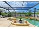 Luxurious backyard pool area with spa, lush landscaping, and ample lounging space under a screened enclosure at 2908 Mayflower St, Sarasota, FL 34231