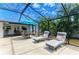 Outdoor living space with a covered seating area, lounge chairs, and lush tropical landscaping at 2908 Mayflower St, Sarasota, FL 34231