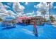 Outdoor dining area of a crab and oyster bar with picnic tables, umbrellas, and a vibrant blue surface at 2908 Mayflower St, Sarasota, FL 34231