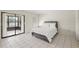 Well-lit bedroom featuring tiled floors, closet space, and a queen-sized bed and backyard views at 314 Oak Hill Way # 24, Sarasota, FL 34232