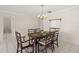 Traditional dining room with a chandelier, wood table and chairs, and tile flooring at 314 Oak Hill Way # 24, Sarasota, FL 34232