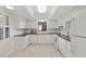 Bright kitchen featuring white cabinets, countertops, and appliances with tile flooring at 314 Oak Hill Way # 24, Sarasota, FL 34232