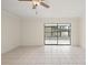 Empty living room features tiled floors, neutral walls, and sliding glass doors to an enclosed porch at 314 Oak Hill Way # 24, Sarasota, FL 34232