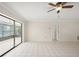 Living room with tile flooring, neutral walls, sliding glass doors to a lanai, and a ceiling fan at 314 Oak Hill Way # 24, Sarasota, FL 34232