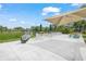 Outdoor seating area with tables, chairs, benches, sunshade, and a water view with fountain in a landscaped community setting at 314 Oak Hill Way # 24, Sarasota, FL 34232
