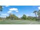 Well-maintained community tennis court surrounded by lush landscaping and mature trees at 314 Oak Hill Way # 24, Sarasota, FL 34232