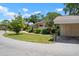 Exterior view featuring a carport, lush lawn, and tree coverage at 3360 Tallywood Ct # 7082, Sarasota, FL 34237