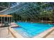 Enclosed pool area featuring comfortable seating, clear blue water, and a sun umbrella at 3360 Tallywood Ct # 7082, Sarasota, FL 34237