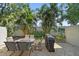 Relaxing backyard features a patio with a barbecue and outdoor table surrounded by lush palms at 3405 54Th W Dr # 102, Bradenton, FL 34210