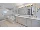 Bathroom featuring double sinks, large mirror, and soaking tub with a stand-alone shower at 3405 54Th W Dr # 102, Bradenton, FL 34210