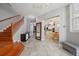 Inviting foyer with wooden staircase, tiled floor, leading to a bright and open-concept kitchen and dining area at 3405 54Th W Dr # 102, Bradenton, FL 34210