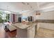 Kitchen breakfast bar with granite countertop and stainless steel dishwasher overlooking a dining and living room area at 3405 54Th W Dr # 102, Bradenton, FL 34210