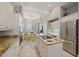 Bright open kitchen featuring an island cooktop with nearby seating, an adjacent dining area, and white cabinetry at 3405 54Th W Dr # 102, Bradenton, FL 34210
