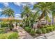 Inviting community entrance with lush tropical landscaping and manicured shrubbery along paver walk way at 3449 Yonge Ave, Sarasota, FL 34235