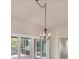 Close-up of a dining room with chandelier and access to an outdoor patio with sliding glass doors at 3449 Yonge Ave, Sarasota, FL 34235