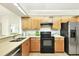 Functional kitchen featuring maple cabinets, laminate countertops, and stainless steel appliances at 3449 Yonge Ave, Sarasota, FL 34235