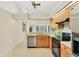 Functional kitchen featuring maple cabinets, laminate countertops, and stainless steel appliances at 3449 Yonge Ave, Sarasota, FL 34235