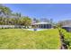 Beautiful backyard with a screened pool, patio area, and lush tropical landscaping creating a private oasis at 3931 Bay Shore Rd, Sarasota, FL 34234