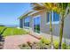 Home exterior with brick patio, sliding glass door, and glimpses of the bay at 3931 Bay Shore Rd, Sarasota, FL 34234