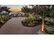 Expansive home with manicured landscaping, including palm trees, a brick driveway, and beach views at 3931 Bay Shore Rd, Sarasota, FL 34234