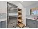 Well-designed kitchen with stainless steel refrigerator and convenient pull out pantry shelves at 3931 Bay Shore Rd, Sarasota, FL 34234