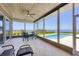 A screened porch with a view of a pool and the ocean with outdoor seating at 3931 Bay Shore Rd, Sarasota, FL 34234